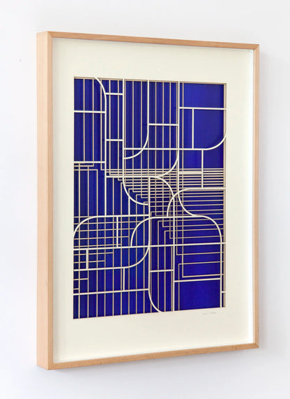 Oblique angled view of the artwork by Jesús Perea, with light highlighting the depth and the layers of die-cut museum board over the blue background.